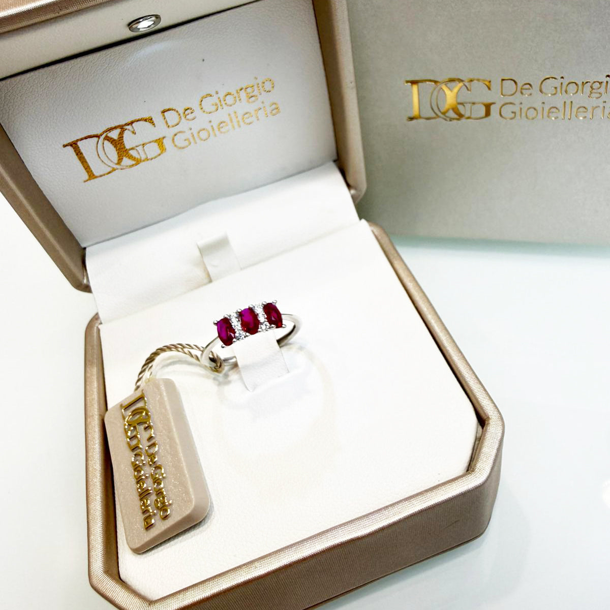 Anello trilogy con pietre rosse e zirconi in oro bianco 18KT (750) – Elegante e raffinato