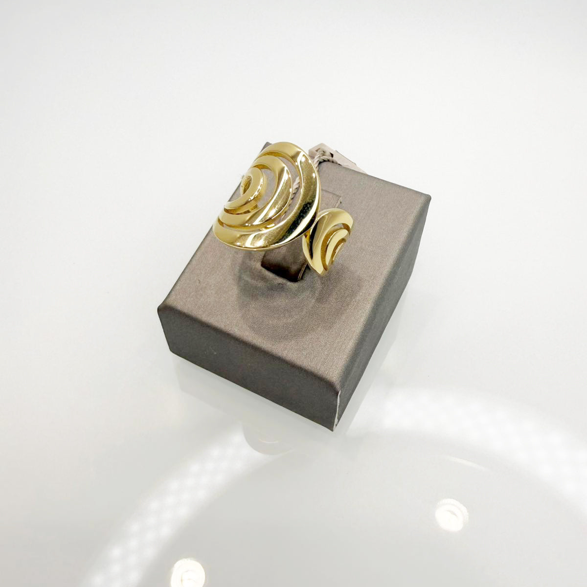 Anello realizzato in oro giallo 18KT (750), caratterizzato da un design moderno e avvolgente con linee morbide e dinamiche.