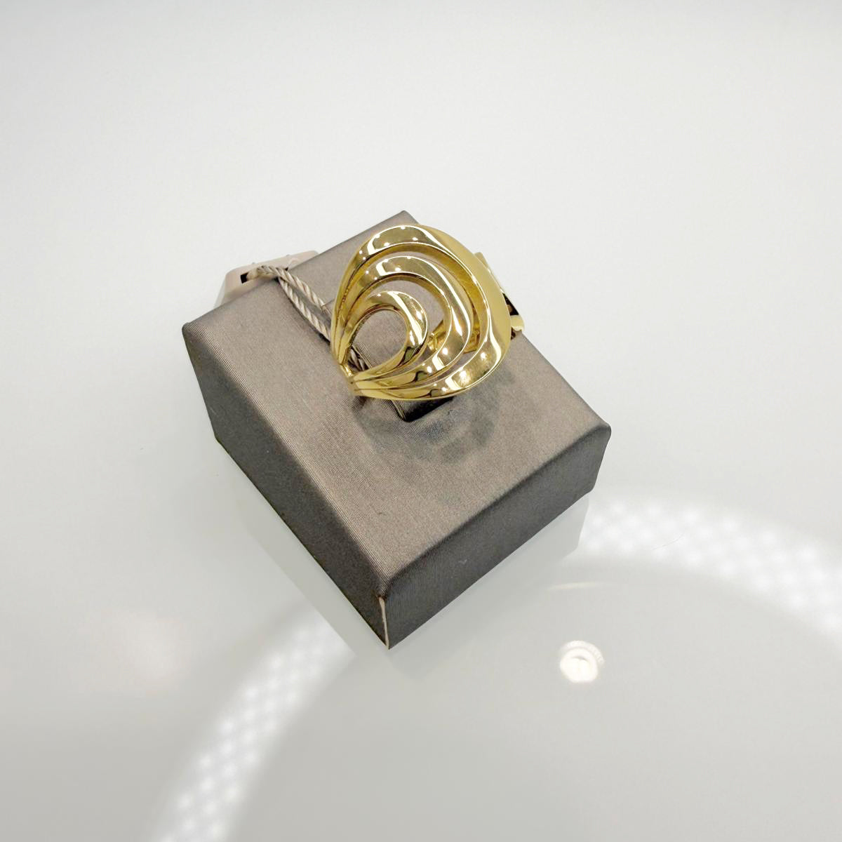 Anello realizzato in oro giallo 18KT (750), caratterizzato da un design moderno e avvolgente con linee morbide e dinamiche.