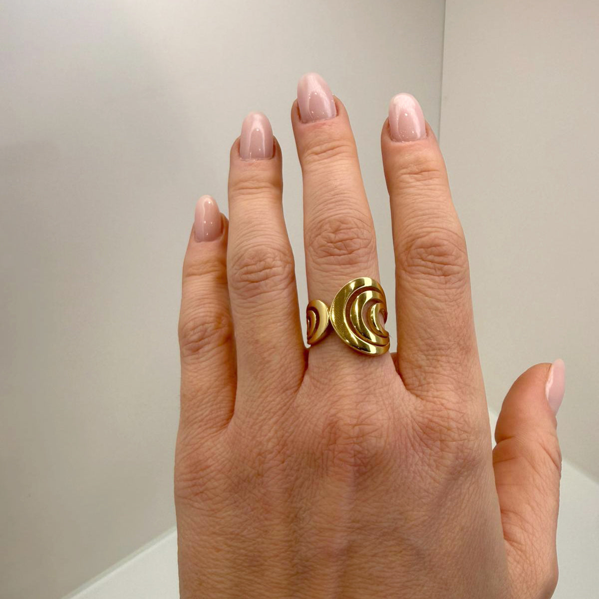 Anello realizzato in oro giallo 18KT (750), caratterizzato da un design moderno e avvolgente con linee morbide e dinamiche.