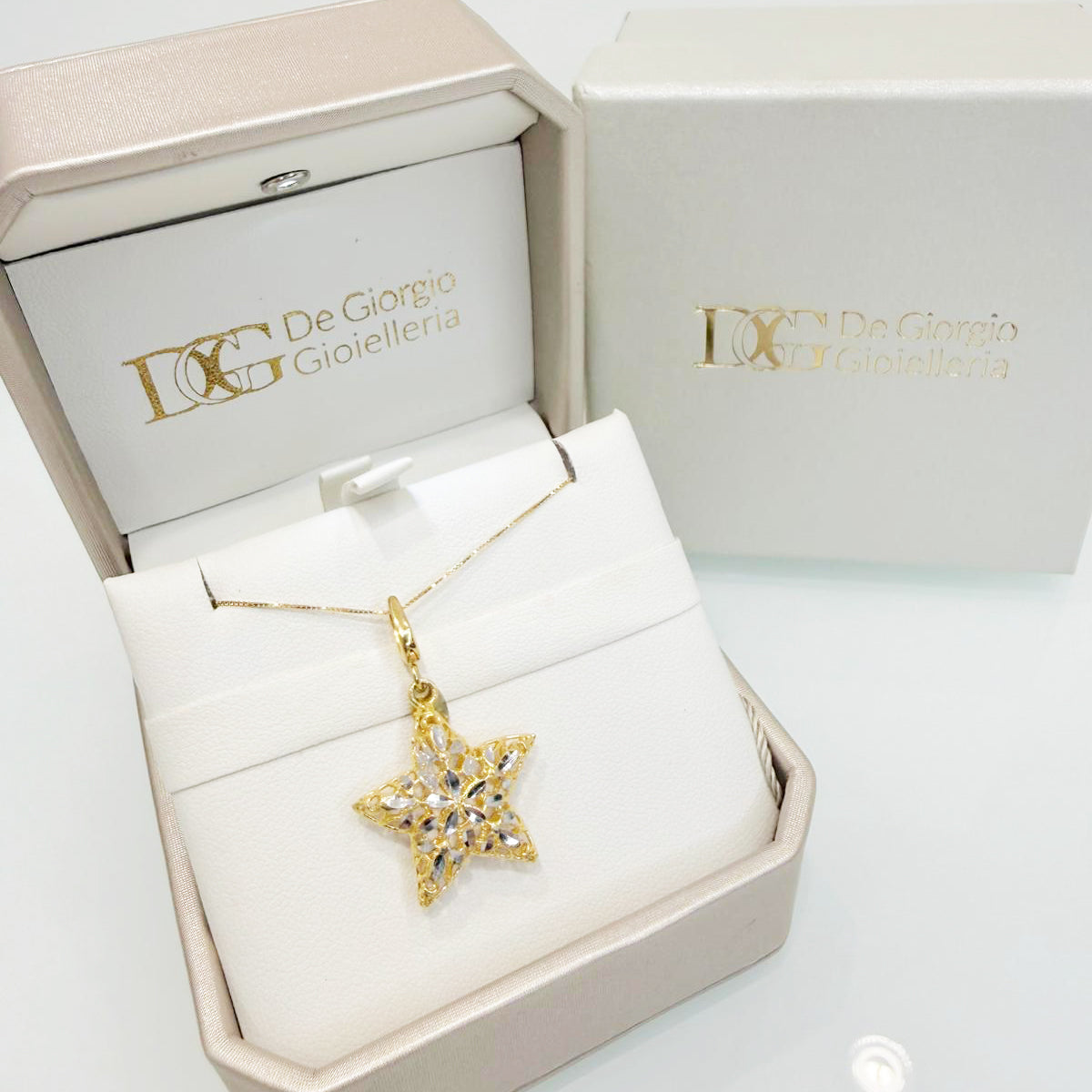 Collana con pendente a stella in oro giallo e bianco 18KT (750) con lavorazione luminosa