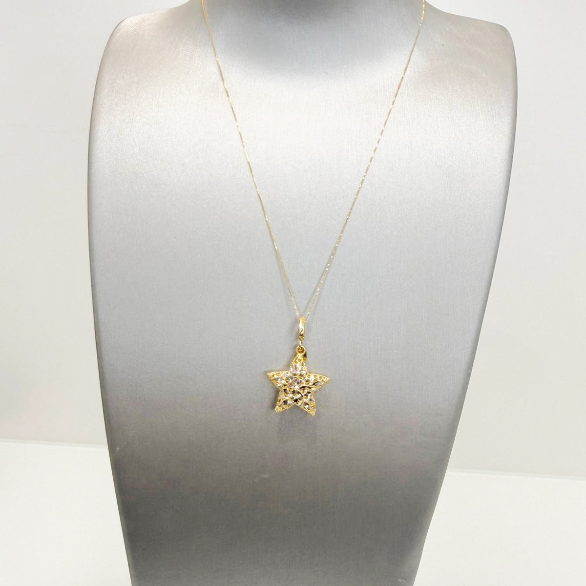 Collana con pendente a stella in oro giallo e bianco 18KT (750) con lavorazione luminosa