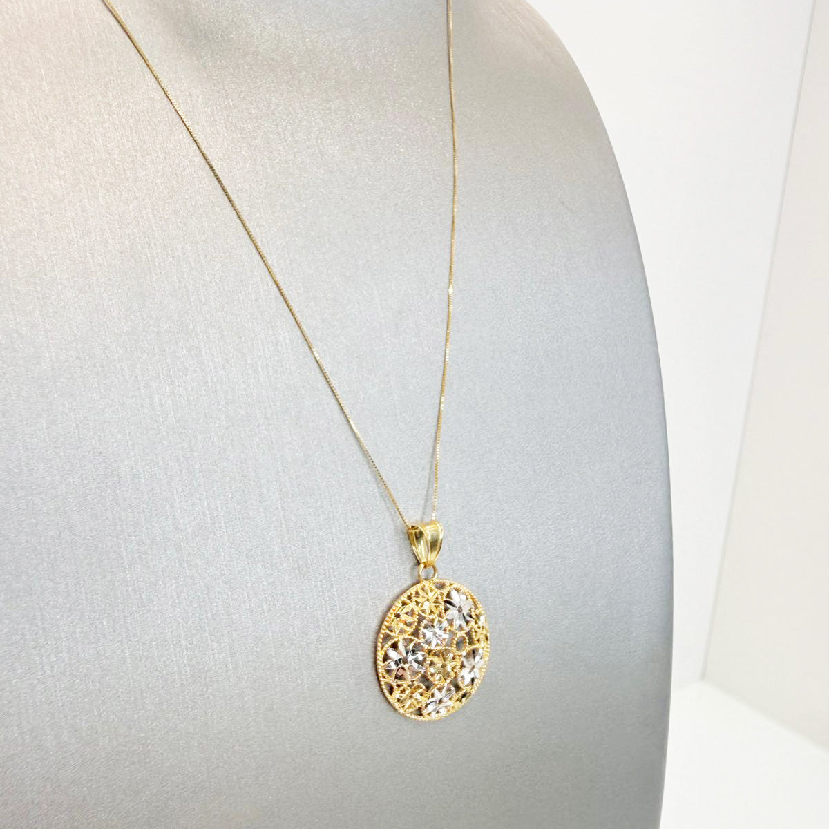 Collana con pendente tondo floreale in oro giallo e bianco 18KT (750) con lavorazione diamantata