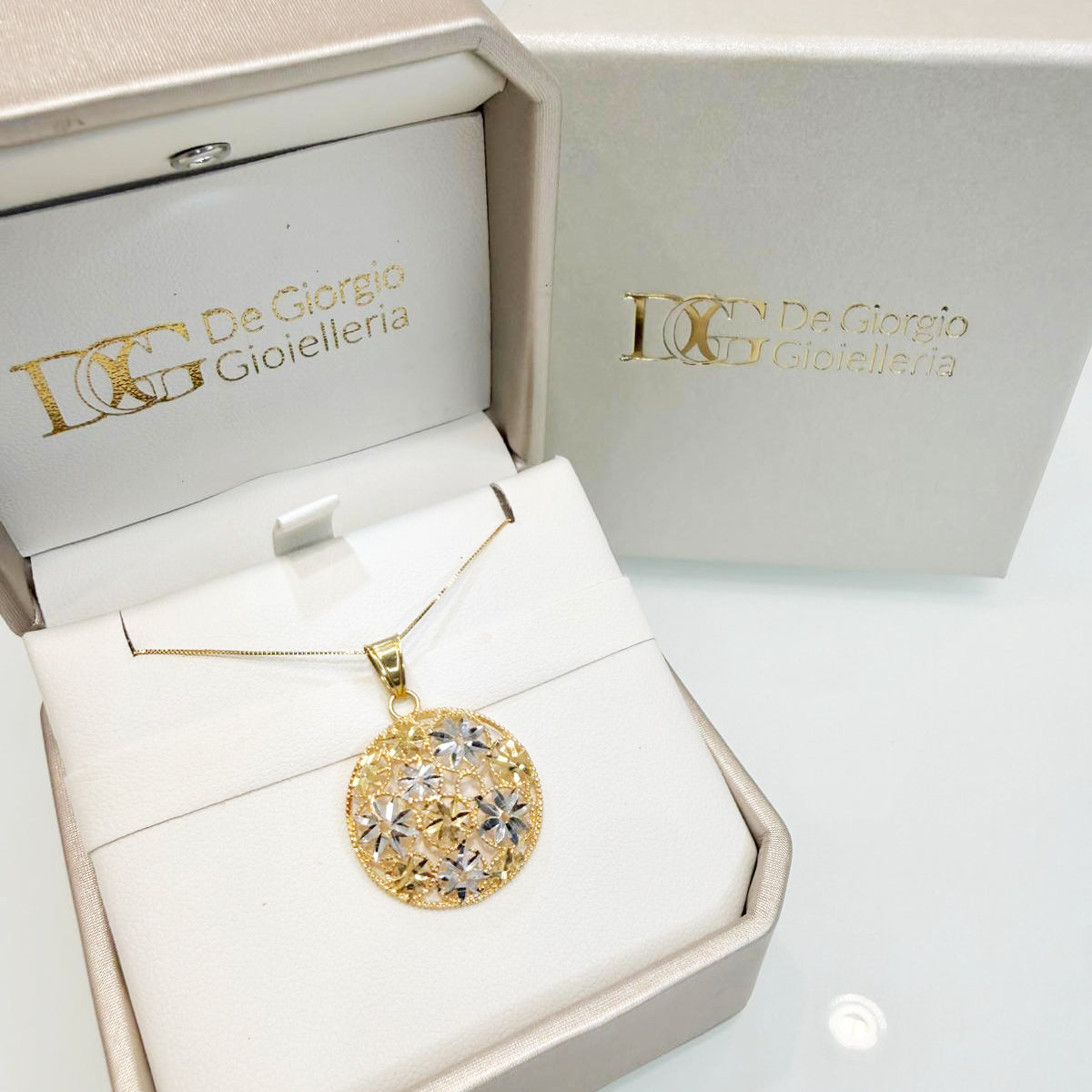 Collana con pendente tondo floreale in oro giallo e bianco 18KT (750) con lavorazione diamantata
